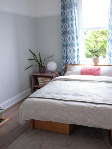 a bedroom with a bed and a window with blue curtains at Penthouse Seaview Warrior Square in Hollington