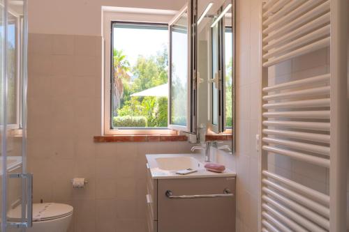 une salle de bain avec un lavabo et une fenêtre dans l'établissement Villa Cammà with private pool, à Mirto