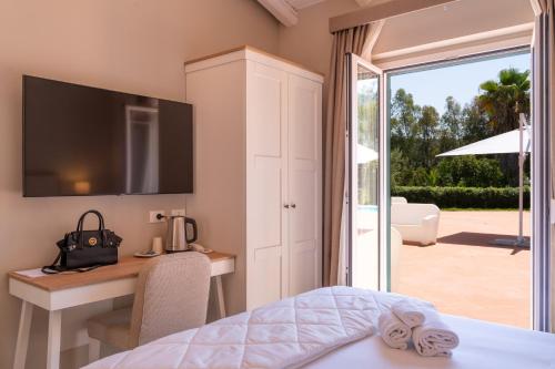 - une chambre avec un lit, un bureau et une porte coulissante en verre dans l'établissement Villa Cammà with private pool, à Mirto