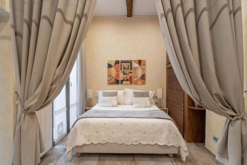 een slaapkamer met een groot bed met gordijnen bij Little Patio in Florence