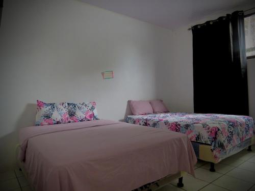 a bedroom with two beds and a window at Rose House Manuel Antonio in Quepos