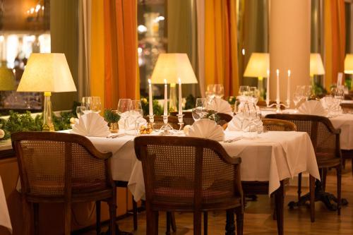 a table with white table cloths and wine glasses on it at Atlantic Parkhotel in Baden-Baden