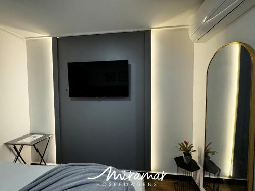 a bedroom with a flat screen tv on a wall at Move - Tambaú in Tambaú