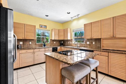 a large kitchen with wooden cabinets and a counter top at Siesta Key Village, Heated Pool, Beach Access 4 min Walk, 3bdr in Siesta Key