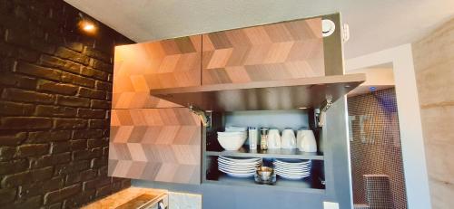 une cuisine avec une étagère et de la vaisselle dans l'établissement Village naturiste Cap d'Agde le Too Hot Coursives, au Cap d'Agde