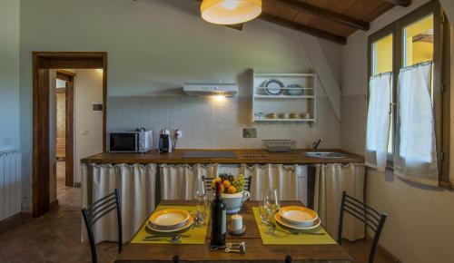 a kitchen with a wooden table and a counter top at Casa Vacanze Le Fornaci in Laterina
