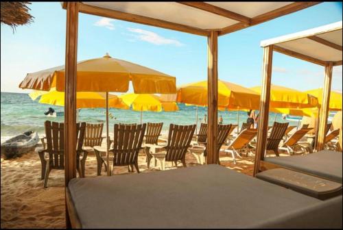 a group of chairs and umbrellas on a beach at Soy Local Barú in Baru