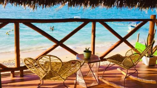 a patio with chairs and a table and the ocean at Soy Local Barú in Baru