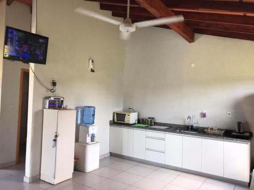a kitchen with a refrigerator and a tv on the wall at Casa Quinta Sagrada Familia de Nazaret in Guarambaré