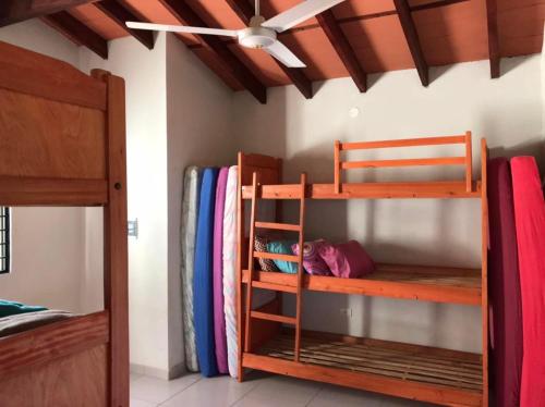 a room with two bunk beds and a ceiling fan at Casa Quinta Sagrada Familia de Nazaret in Guarambaré