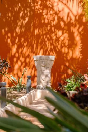 a stone statue sitting in the middle of a garden at Holiday Inn Express Merida Centro by IHG in Mérida