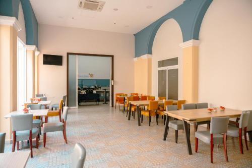 a dining room with tables and chairs at Holiday Inn Express Merida Centro by IHG in Mérida