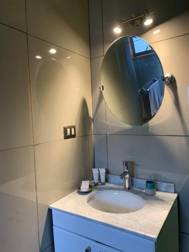 a bathroom with a sink and a mirror at Lodge Cumbres de Chiloe in Castro