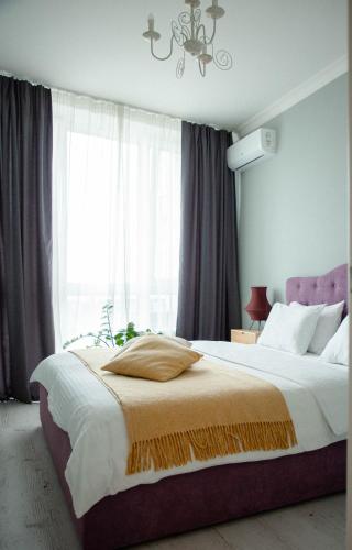 a bedroom with a large bed with a large window at Slavutich apartment number 3 in Kyiv