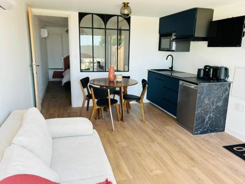 a living room with a kitchen and a table with chairs at L anse des Imperiales 1 in Collioure