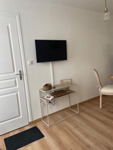 Cette chambre dispose d'une télévision murale et d'une table. dans l'établissement Au coeur de la baie, à Saint-Valery-sur-Somme