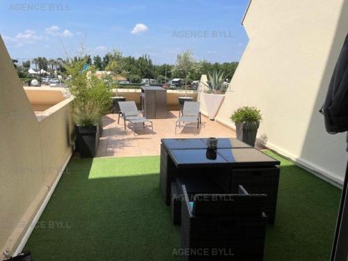 d'un balcon sur le toit avec une table et des chaises. dans l'établissement Résidence Héliopolis Bâtiment K - Studio 2 pers. Héliopolis K MAE-4604, au Cap d'Agde