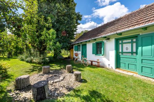 a green and white house with a yard at Carpe diem Vendégház in Cserépfalu
