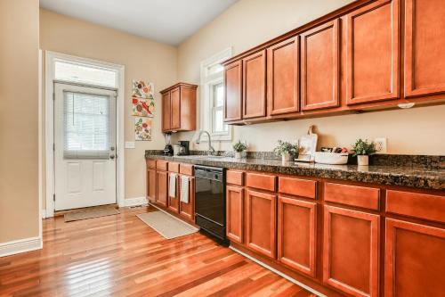 a kitchen with wooden cabinets and a black dishwasher at Near Starland & River St - Private Patio & BBQ - Parking in Savannah