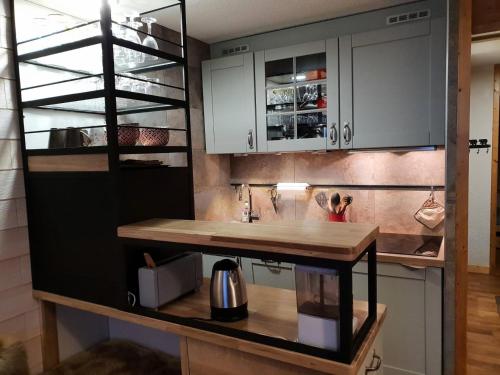 une cuisine avec des armoires blanches et un comptoir en bois dans l'établissement Résidence Creux De L Ours D - CREUX DE L OURS D67 MAE-4121, à Les Allues