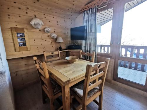 une salle à manger avec une table et des chaises en bois dans l'établissement Résidence Arpasson - ARPASSON 80 MAE-4161, à Les Allues