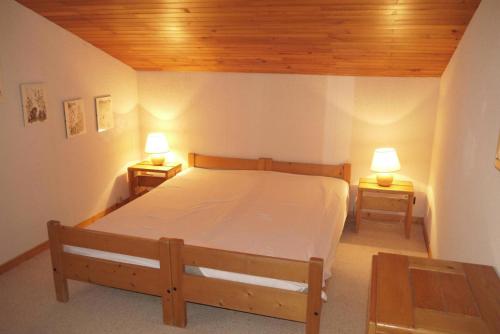 - une chambre avec un lit et deux lampes sur deux tables dans l'établissement Résidence Arc En Ciel - ARC EN CIEL G12<br /> MAE-4181, à Les Allues