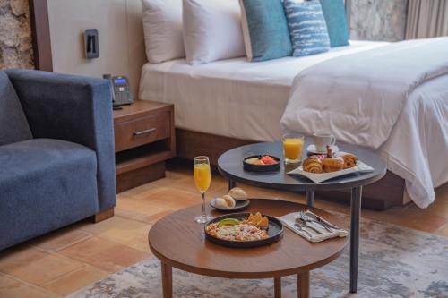 a room with a bed and a table with food and drinks at Hacienda Santo Cristo Hotel & Spa - Adults Only in Atlixco