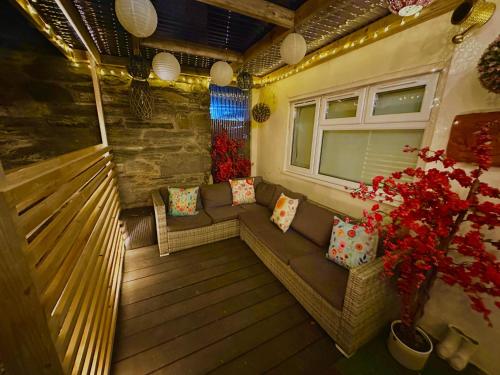 a small balcony with a couch and a window at Zip Cottage Sleeps 2-3 climb snowdon zip world in Tanygrisiau