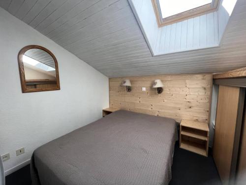 - une petite chambre avec un lit et une lucarne dans l'établissement Résidence Pralin - PRALIN 1111 MAE-4251, à Les Allues