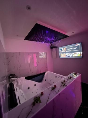 une pièce violette avec une baignoire avec un plafond violet dans l'établissement La suite mercure jacuzzi, à Pont-Saint-Esprit