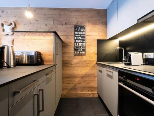 - une cuisine avec des murs en bois et un comptoir dans l'établissement Résidence Plan Du Lac - PLAN DU LAC 112 MAE-4371, à Les Allues