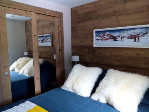 une chambre avec deux miroirs et un lit avec des draps blancs dans l'établissement Résidence Plan Du Lac - PLAN DU LAC 112 MAE-4371, à Les Allues