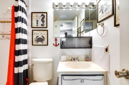 a bathroom with a sink and a toilet and a mirror at Captain's Quarters in Ocean City