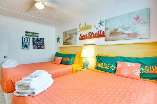 two beds in a room with orange and green at Captain's Quarters in Ocean City