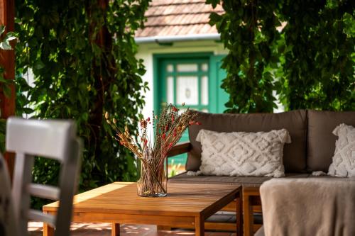 a wooden table with a vase of flowers on it at Carpe diem Vendégház in Cserépfalu