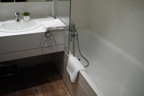 une salle de bain blanche avec un lavabo et une baignoire dans l'établissement Résidence Arpasson - ARPASSON 18 MAE-4401, à Les Allues