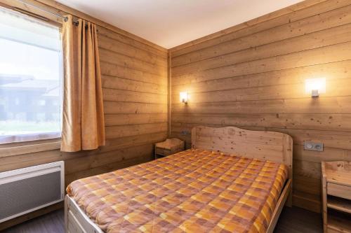 une chambre avec un lit dans un mur en bois dans l'établissement Résidence Arpasson - ARPASSON 22 MAE-4411, à Les Allues