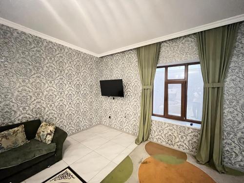 Una sala de estar con un sofá y una ventana. en Qabala KOMFORT Villa, en Gabala