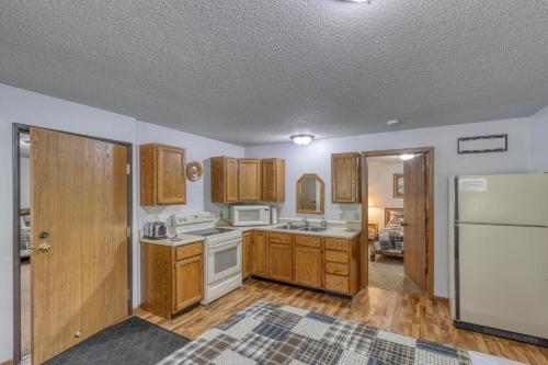 a kitchen with white appliances and wooden cabinets at Buffalo Thunder Lodge in Deadwood