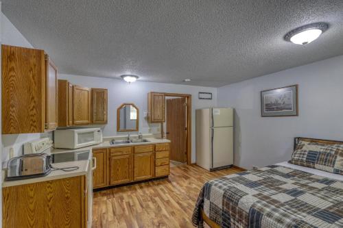 a kitchen with a bed and a sink and a refrigerator at Buffalo Thunder Lodge in Deadwood