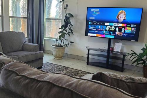 a living room with a couch and a flat screen tv at Lovely Room 1 Near San Marcosatx in Kyle