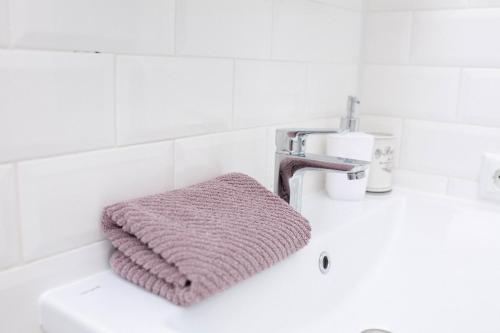 Una toalla rosa sobre el lavabo del baño. en Slavutich apartment #2, en Kiev