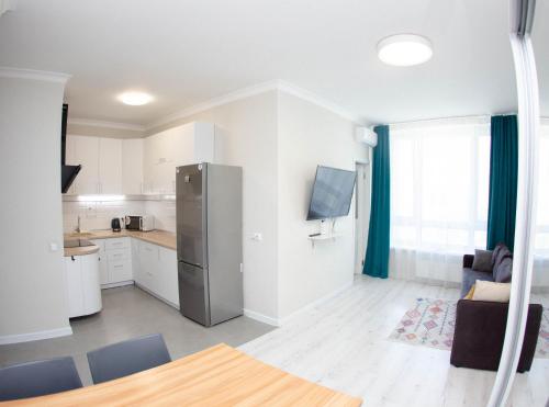 Una cocina con refrigerador de acero inoxidable en una habitación. en Slavutich apartment #2, en Kiev