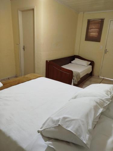 a bedroom with two beds with white sheets at Caminito in Santo Antônio do Pinhal