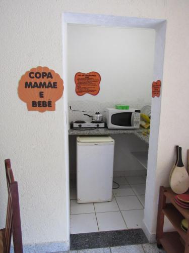 a small kitchen with a refrigerator and a microwave at Pousada Casa na Praia in Ubatuba
