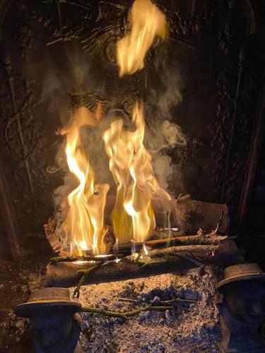 un feu sort d'un four en pierre dans l'établissement Villa Roulage Ferme 18ème Jardin Parking Normandie Plage, à Longueville