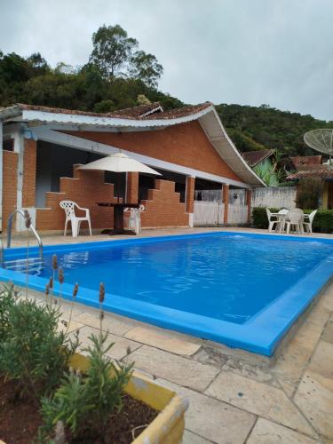 a large blue swimming pool in front of a house at Caminito in Santo Antônio do Pinhal