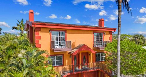 a yellow and orange house with palm trees at Siesta Key Village, Heated Pool, Beach Access 4 min Walk, 3bdr in Siesta Key