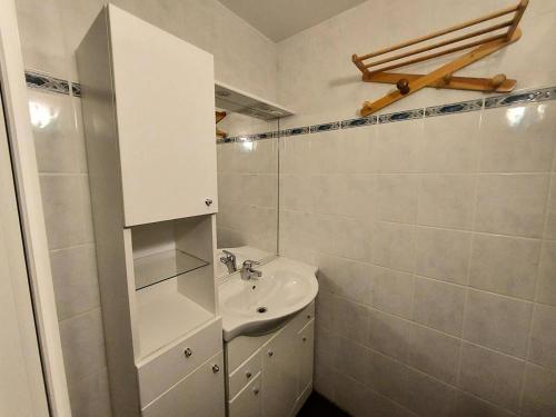 une salle de bain blanche avec un lavabo et un miroir dans l'établissement Résidence Les Hameaux I - Résidence LES HAMEAUX 1 N°360 MAE-4931, à La Plagne Tarentaise