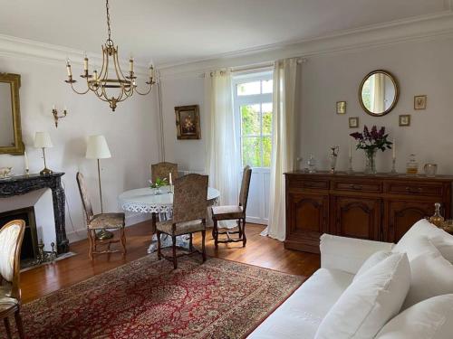 un salon avec un canapé blanc et une table dans l'établissement Villa Roulage Ferme 18ème Jardin Parking Normandie Plage, à Longueville